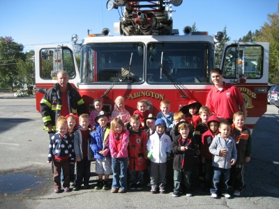 Children and fireman pose in front of an Abington Fire Dept Truck